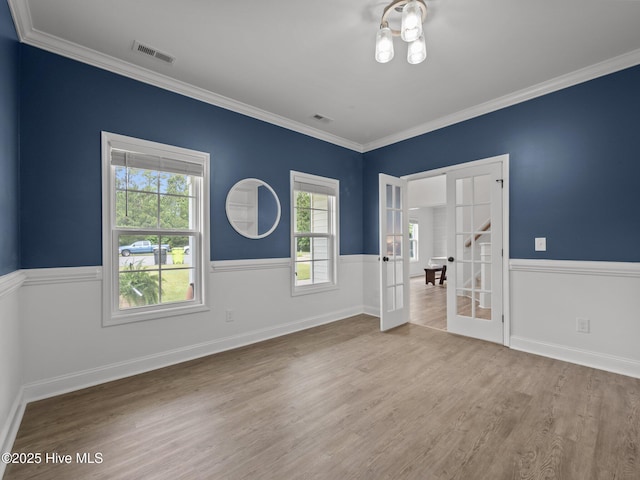 608 Creek Ct, Swansboro, NC 28584 - unfurnished bedroom featuring french doors, wood finished floors, a wainscoted wall, and ornamental molding