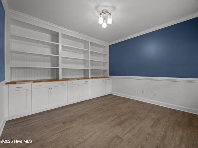 608 Creek Ct, Swansboro, NC 28584 - empty room featuring dark wood-type flooring, ornamental molding, baseboards, and built in shelves