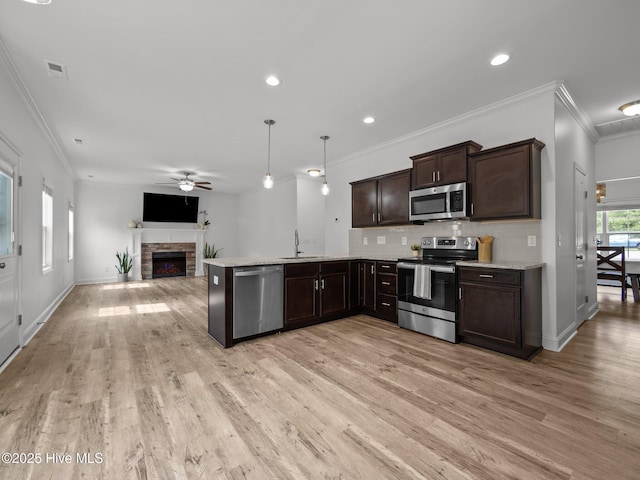 608 Creek Ct, Swansboro, NC 28584 - kitchen featuring appliances with stainless steel finishes, crown molding, open floor plan, ceiling fan, and dark brown cabinetry