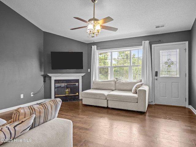 329 Buckhead Rd, Hubert, NC 28539 - living area featuring a ceiling fan, a glass covered fireplace, wood finished floors, vaulted ceiling, and baseboards