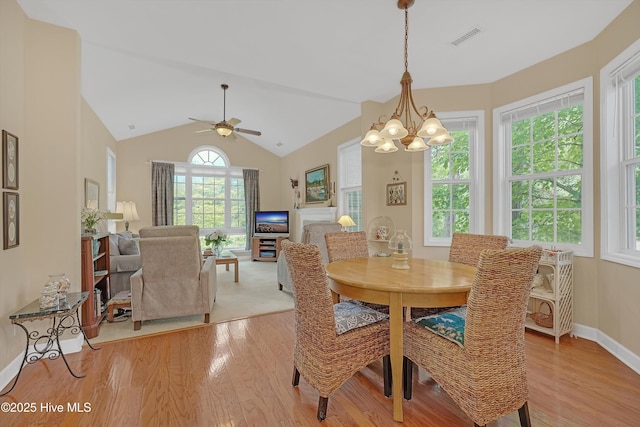3856 Harmony Cir, Southport, NC 28461 - dining space with light wood-type flooring, a chandelier, a ceiling fan, baseboards, and lofted ceiling