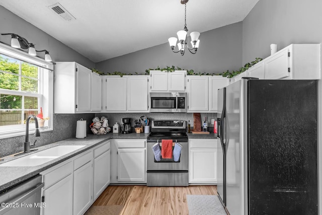 425 Dion Dr, Hubert, NC 28539 - kitchen with stainless steel appliances, a sink, vaulted ceiling, white cabinets, and light wood-style flooring