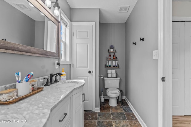 425 Dion Dr, Hubert, NC 28539 - bathroom featuring vanity, toilet, baseboards, and stone finish flooring