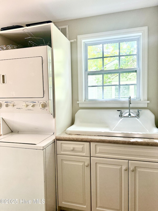2210 Klein Rd, Wilmington, NC 28405 - laundry room featuring stacked washer / dryer and cabinet space