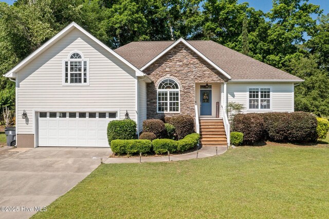 1682 Gores Landing Rd SW, Ocean Isle Beach, NC 28469 - view of front of house with driveway, a front lawn, stone siding, and an attached garage