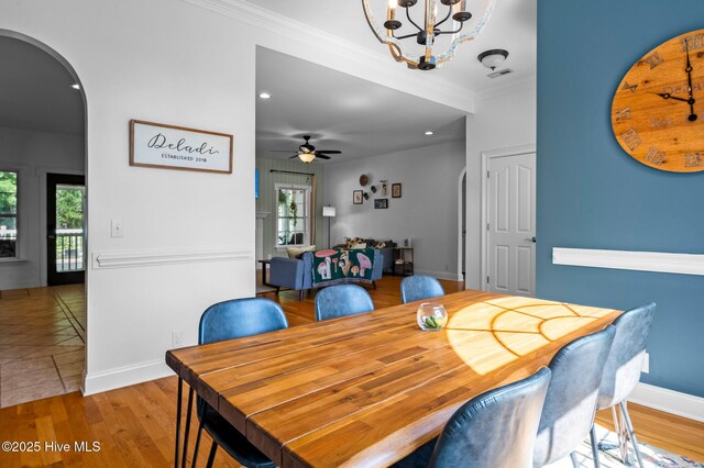 1682 Gores Landing Rd SW, Ocean Isle Beach, NC 28469 - dining room featuring arched walkways, healthy amount of natural light, baseboards, a chandelier, and ornamental molding