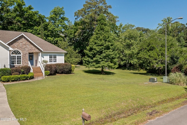 1682 Gores Landing Rd SW, Ocean Isle Beach, NC 28469 - view of front of house featuring a front yard, stone siding, and a shingled roof