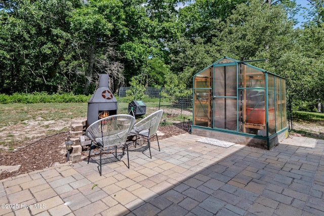 1682 Gores Landing Rd SW, Ocean Isle Beach, NC 28469 - view of patio / terrace with a lit fireplace and a greenhouse