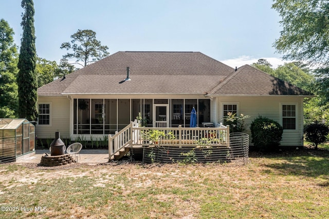 1682 Gores Landing Rd SW, Ocean Isle Beach, NC 28469 - rear view of property featuring a sunroom, a greenhouse, a yard, an outbuilding, and a shingled roof