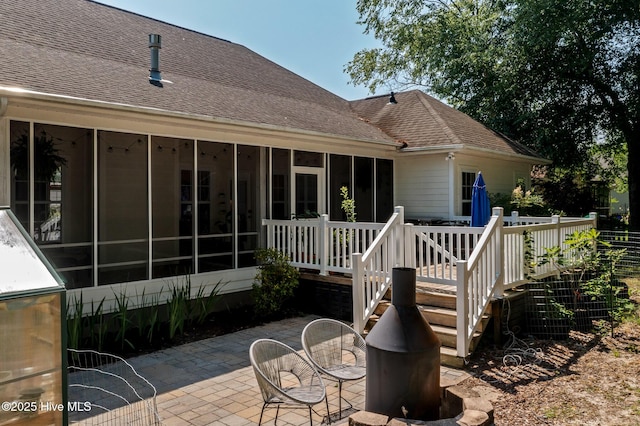 1682 Gores Landing Rd SW, Ocean Isle Beach, NC 28469 - rear view of house with a sunroom, a patio area, a shingled roof, and a deck