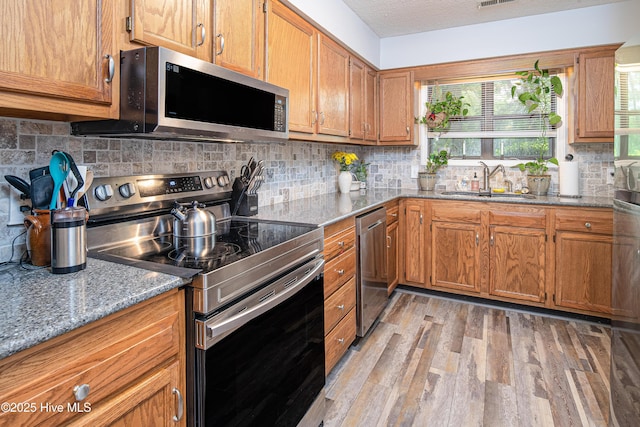 923 Persimmon Pl, Winterville, NC 28590 - kitchen featuring stainless steel appliances, a sink, light wood finished floors, light stone countertops, and tasteful backsplash