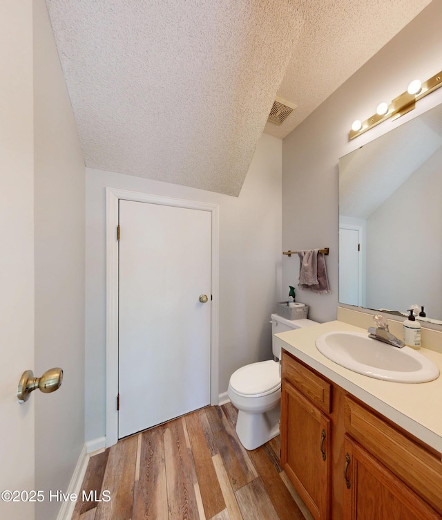 923 Persimmon Pl, Winterville, NC 28590 - bathroom featuring a textured ceiling, vaulted ceiling, vanity, wood finished floors, and toilet