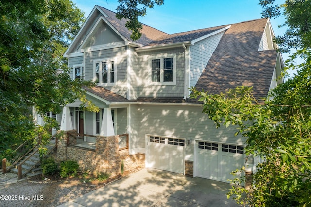 1911 Middle Sound Loop Rd, Wilmington, NC 28411 - view of front of home featuring driveway, a porch, an attached garage, and stone siding