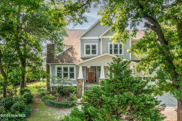 1911 Middle Sound Loop Rd, Wilmington, NC 28411 - view of front facade with a chimney, a porch, and a shingled roof