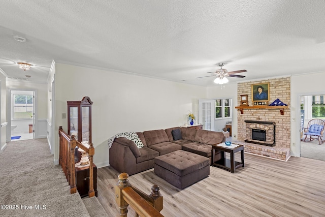 418 Grants Creek Rd, Jacksonville, NC 28546 - living room with a textured ceiling, crown molding, a brick fireplace, a ceiling fan, and light wood finished floors