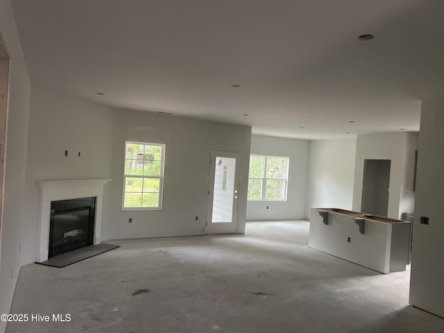 3035 Old Berwick St SW, Shallotte, NC 28470 - unfurnished living room with a fireplace with raised hearth and concrete floors