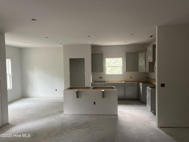 3035 Old Berwick St SW, Shallotte, NC 28470 - kitchen with a center island, gray cabinets, and concrete flooring