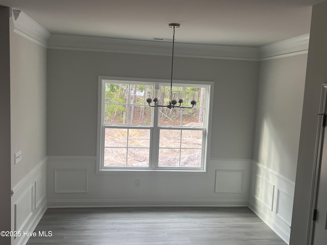 3134 Brackenbury St SW, Shallotte, NC 28470 - unfurnished dining area with plenty of natural light, a chandelier, wainscoting, wood finished floors, and ornamental molding