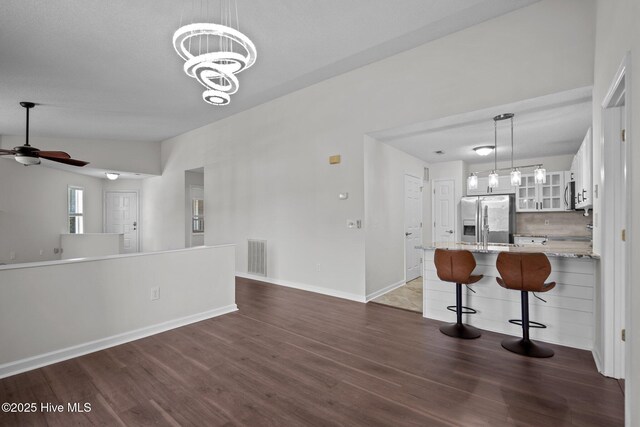 4109 Breezewood Dr Unit 204, Wilmington, NC 28412 - kitchen with stainless steel appliances, dark wood finished floors, white cabinetry, glass insert cabinets, and light stone counters