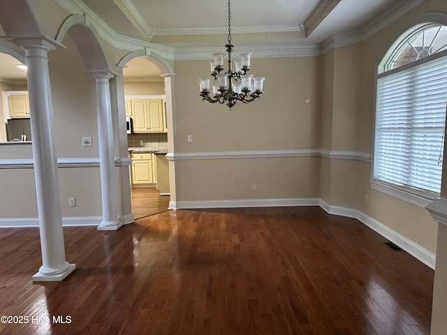 315 Hunters Creek Dr, Goldsboro, NC 27534 - unfurnished dining area with healthy amount of natural light, dark wood-type flooring, a chandelier, arched walkways, and crown molding