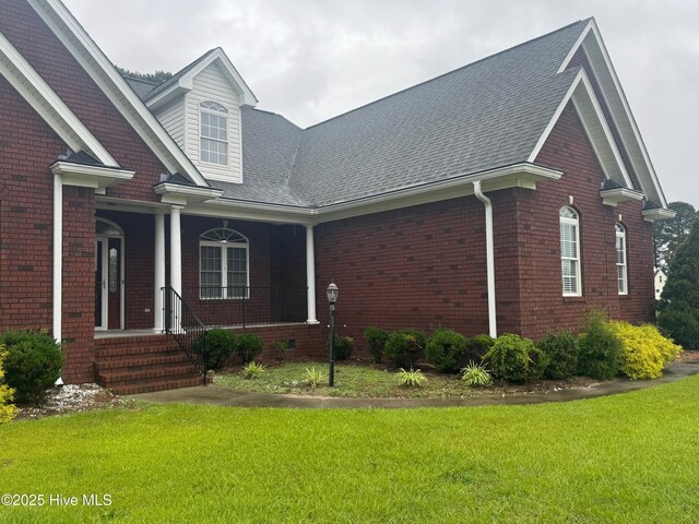 315 Hunters Creek Dr, Goldsboro, NC 27534 - view of front of home featuring a front yard, brick siding, roof with shingles, and a porch