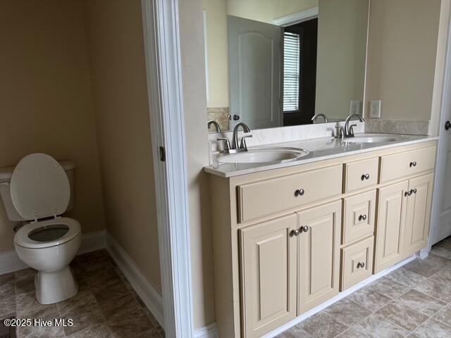 315 Hunters Creek Dr, Goldsboro, NC 27534 - full bathroom with double vanity, toilet, and baseboards