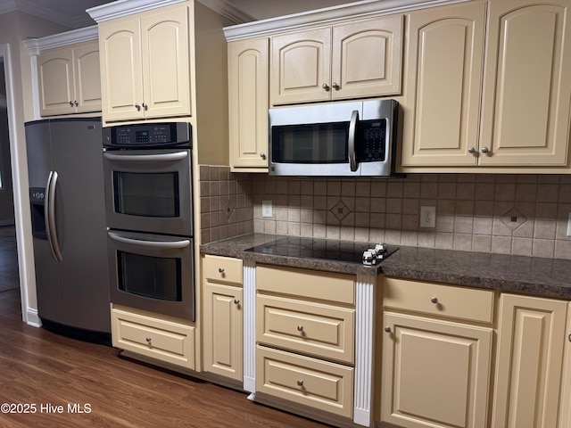 315 Hunters Creek Dr, Goldsboro, NC 27534 - kitchen featuring stainless steel appliances, cream cabinets, dark countertops, and ornamental molding