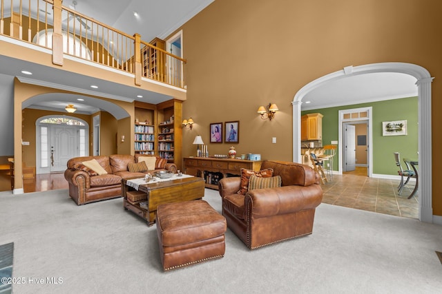 118 Douglas Dr, West End, NC 27376 - carpeted living area featuring arched walkways, crown molding, a towering ceiling, recessed lighting, and decorative columns