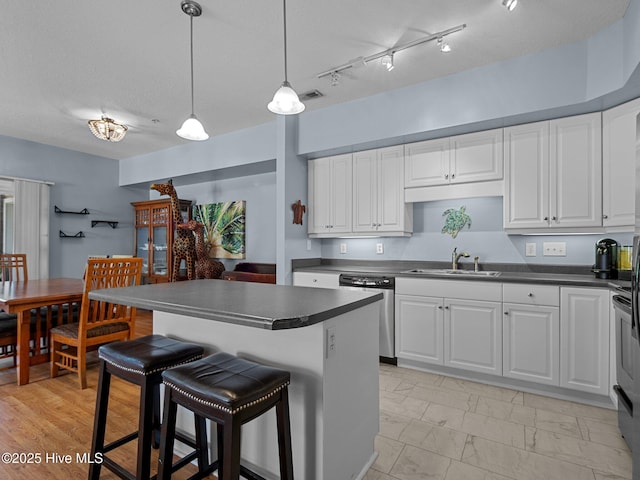 300 Lighthouse Ln Unit C2, Cedar Point, NC 28584 - kitchen featuring stainless steel dishwasher, a sink, dark countertops, and white cabinets