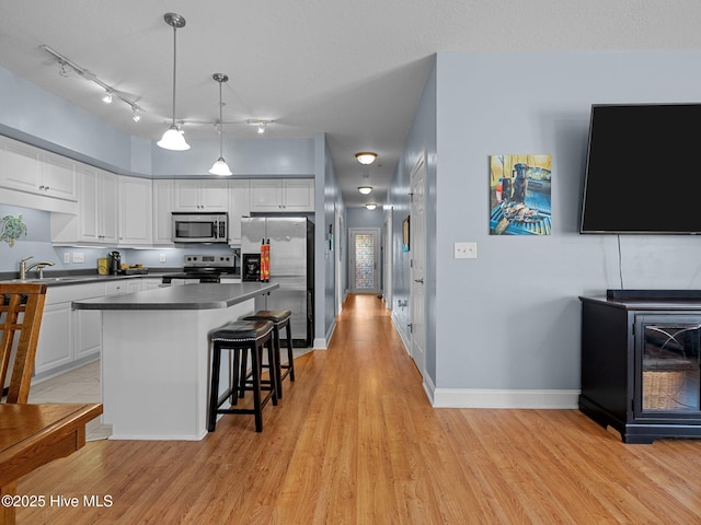 300 Lighthouse Ln Unit C2, Cedar Point, NC 28584 - kitchen featuring stainless steel appliances, light wood finished floors, white cabinetry, dark countertops, and a sink