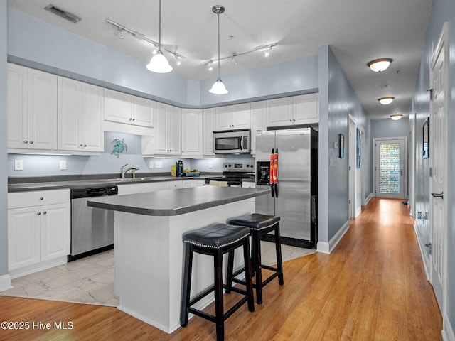 300 Lighthouse Ln Unit C2, Cedar Point, NC 28584 - kitchen with stainless steel appliances, dark countertops, white cabinets, and a kitchen island