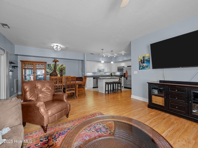 300 Lighthouse Ln Unit C2, Cedar Point, NC 28584 - living area with light wood-style flooring, baseboards, and a textured ceiling