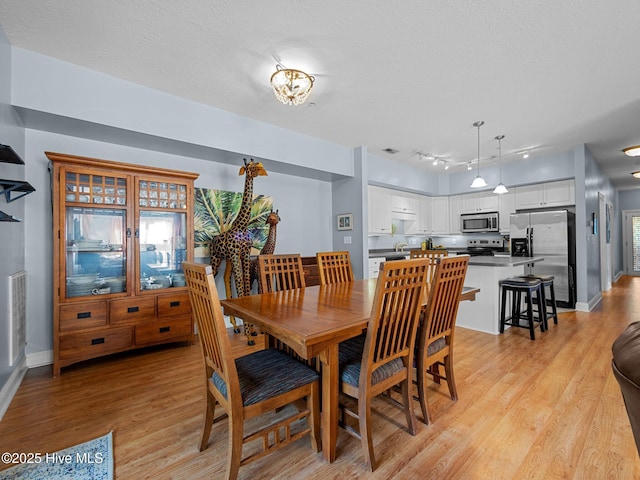 300 Lighthouse Ln Unit C2, Cedar Point, NC 28584 - dining room with light wood-style flooring, baseboards, and a textured ceiling