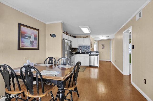 101 W First St # A2, Ocean Isle Beach, NC 28469 - dining room with wood finished floors, baseboards, and ornamental molding