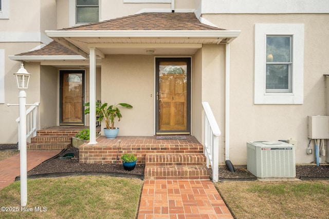103 Continental Dr Unit 3, Elizabeth City, NC 27909 - doorway to property with central air condition unit, stucco siding, and a shingled roof