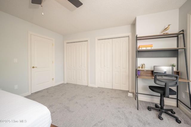 103 Continental Dr Unit 3, Elizabeth City, NC 27909 - carpeted bedroom with two closets, an office area, a textured ceiling, a ceiling fan, and baseboards