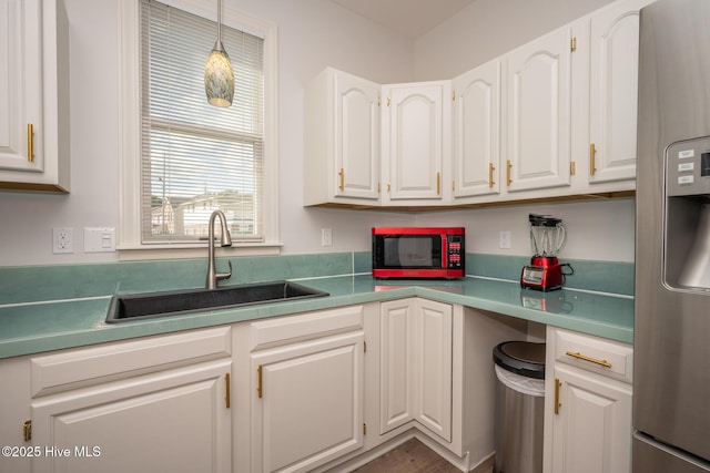 103 Continental Dr Unit 3, Elizabeth City, NC 27909 - kitchen with stainless steel fridge, a sink, white cabinets, pendant lighting, and light countertops
