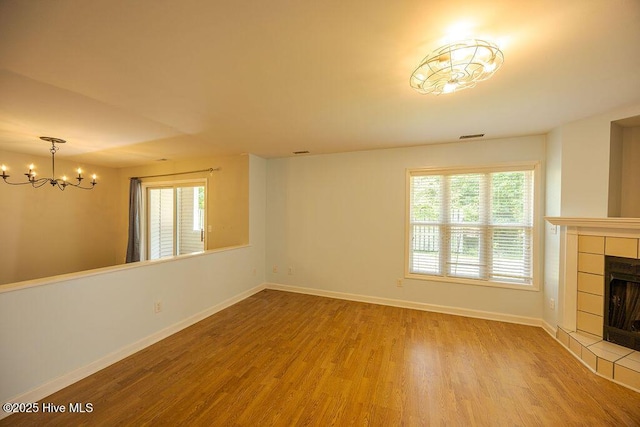421 Commerce Ave Unit B, Morehead City, NC 28557 - unfurnished living room featuring a chandelier, wood finished floors, a fireplace, and baseboards