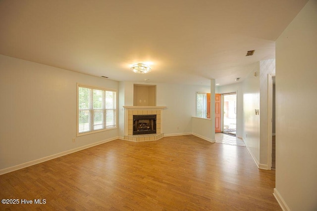 421 Commerce Ave Unit B, Morehead City, NC 28557 - unfurnished living room featuring light wood-style flooring, baseboards, and a tile fireplace