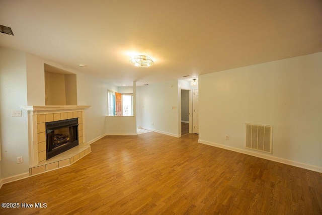 421 Commerce Ave Unit B, Morehead City, NC 28557 - unfurnished living room with wood finished floors, a tiled fireplace, and baseboards