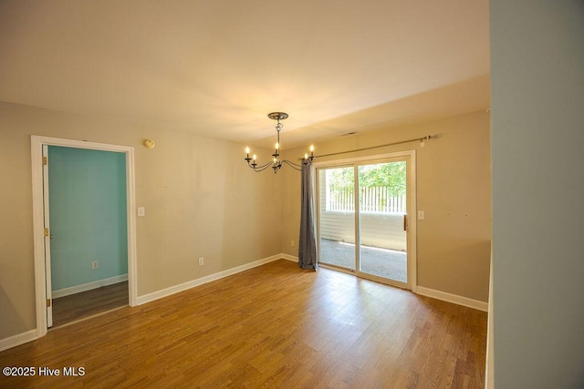 421 Commerce Ave Unit B, Morehead City, NC 28557 - unfurnished room featuring a chandelier, wood finished floors, and baseboards