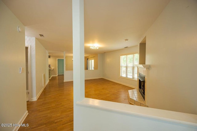 421 Commerce Ave Unit B, Morehead City, NC 28557 - unfurnished living room featuring a tile fireplace, wood finished floors, and baseboards