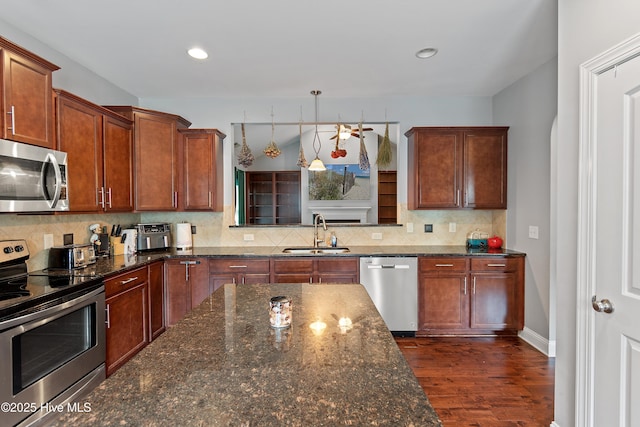 1678 Old Salt SW, Shallotte, NC 28470 - kitchen featuring stainless steel appliances, a sink, dark wood finished floors, backsplash, and dark stone countertops