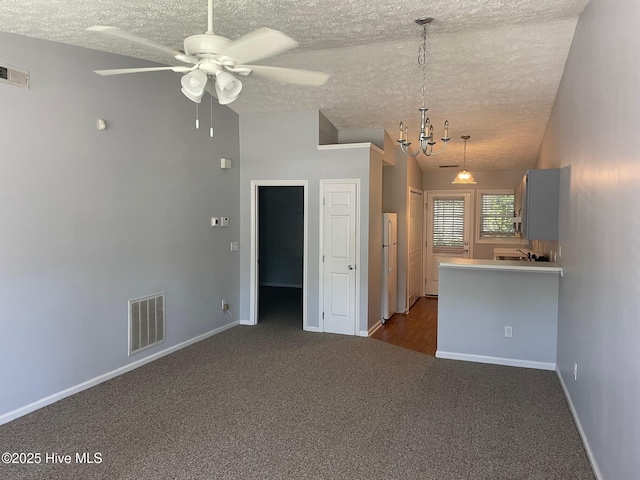 713 Varsity Dr, Wilmington, NC 28403 - unfurnished living room with dark carpet, a textured ceiling, ceiling fan, a chandelier, and vaulted ceiling