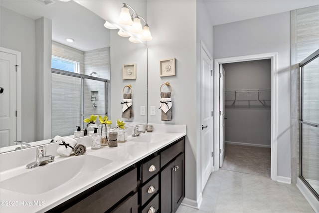 658 Edgeside Dr SE, Bolivia, NC 28422 - bathroom featuring a shower stall, double vanity, tile patterned floors, a spacious closet, and baseboards
