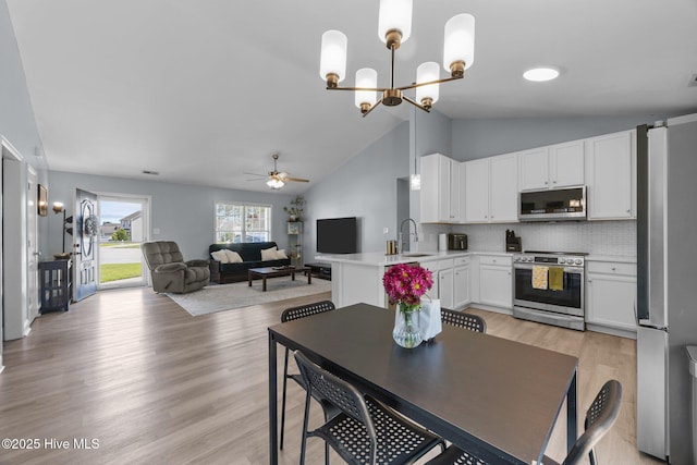 1014 Ponderosa Pl, Jacksonville, NC 28546 - dining area with ceiling fan, light wood-type flooring, a chandelier, and high vaulted ceiling