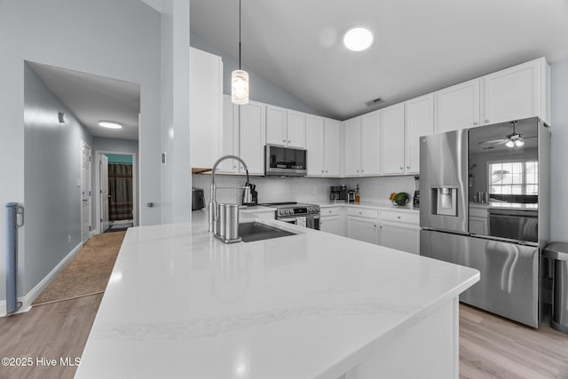 1014 Ponderosa Pl, Jacksonville, NC 28546 - kitchen with appliances with stainless steel finishes, light wood-style floors, lofted ceiling, backsplash, and white cabinetry