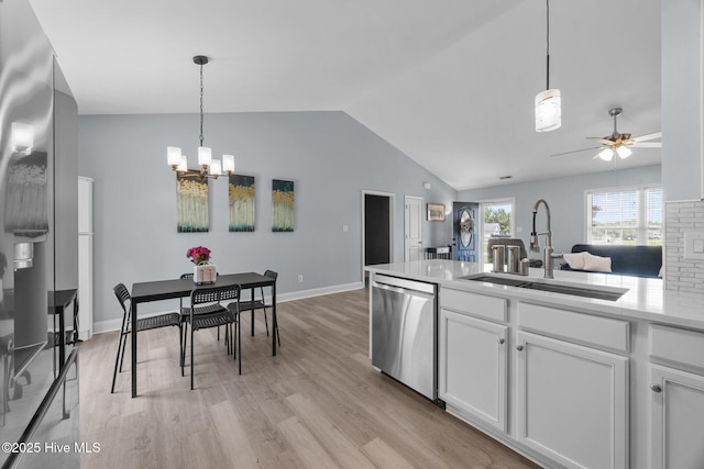 1014 Ponderosa Pl, Jacksonville, NC 28546 - kitchen with stainless steel dishwasher, a sink, vaulted ceiling, a chandelier, and white cabinets