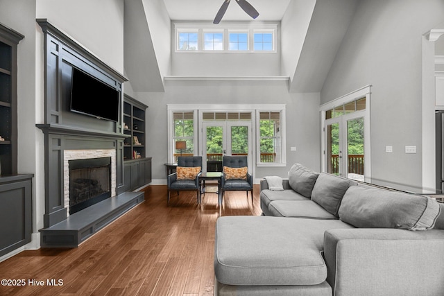 137 Summerset Lndg, Hampstead, NC 28443 - living area with a high ceiling, ceiling fan, a stone fireplace, plenty of natural light, and wood finished floors