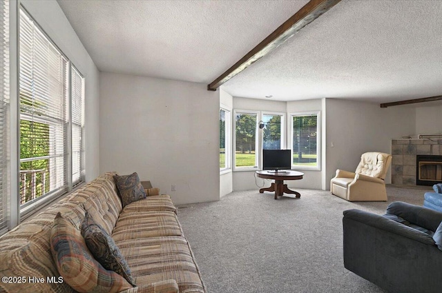 5685 Watts Rd SW, Ocean Isle Beach, NC 28469 - living room featuring a textured ceiling, carpet flooring, a tiled fireplace, and beam ceiling